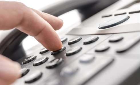 Finger hitting telephone number keys